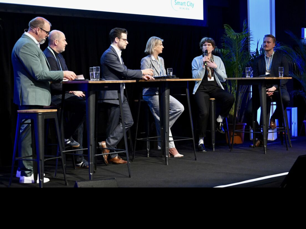 Das Bild zeigt die Podiumsdiskussion auf dem 20. Regionalkongress in Mönchengladbach, bei der sechs Expert*innen zum Thema "Wie wird Smart City für alle erfahrbar?" austauschen.