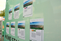 Man sieht die Seitenwand des städtischen Anhängers (mintgrün) auf der 7 große Plakate aufgehängt sind, die die Projekte erklären. 