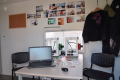Das Foto wurde innen im Anhänger aufgenommen. man sieht einen Tisch mit einem Laptop und einem 3D-Drucker, am Tisch stehen zwei schwarze Stühle.