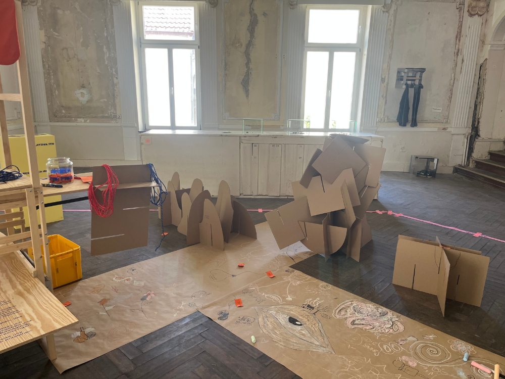 Das Foto zeigt einen Raum im verlassenen Hotel Nadler, mit abgerissenen Tapeten und zwei Fenstern durch die Licht fällt.