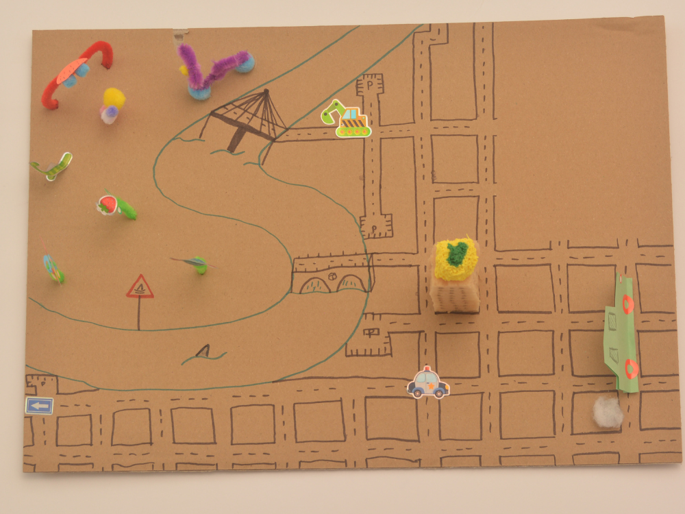 Das Foto zeigt das gebastelte Stadtmodell, das ähnlich einer amerikanischen Stadt sehr linear aufgebaut ist. Das klare Straßennetz ist aufgemalt, aus Pfeifenreinigern wurden weitere phantasievolle Elemente gestaltet.