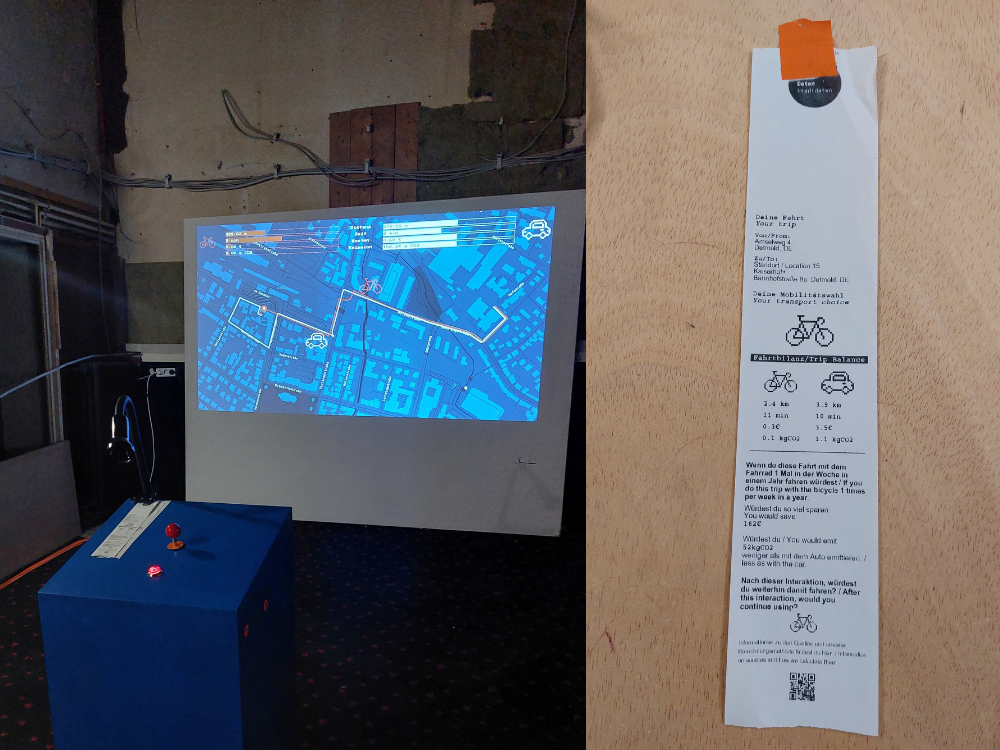 Projektionskarte einer Stadt mit markierten Routen auf einer Wand neben einem langen, schmalen Informationszettel mit Fahrrad- und Auto-Icons und Text in deutscher Sprache.