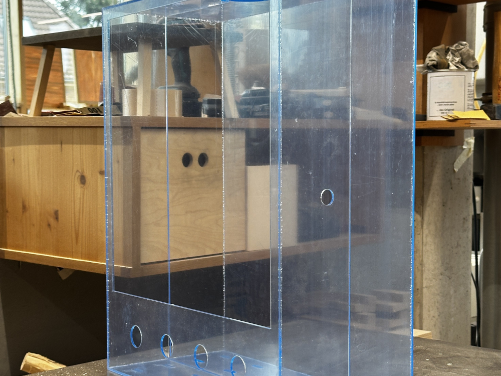Das Bild zeigt einen individuell gebauten Plexiglasrahmen für das Dezentrale Interface.