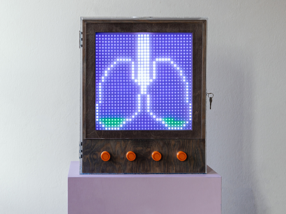 Das Foto zeigt das fertig gebaute dezentrale Interface, das eine Lunge aus LED-Lämpchen abbildet und über vier rote Abstimmungsknöpfe verfügt.