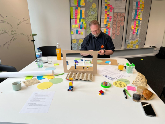 Ein Teilnehmer des Workshops baut ein Modell aus zahlreichen Materialien. 