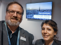 Ein Mann mit Bart und Brille und eine junge Frau sind großformatig auf dem Foto zu sehen und lächeln in die Kamera. Im Hintergrund sieht man einen Bildschirm, der auf die Regionalkonferenz am 5. Februar 2025 in Osnabrück hinweist.