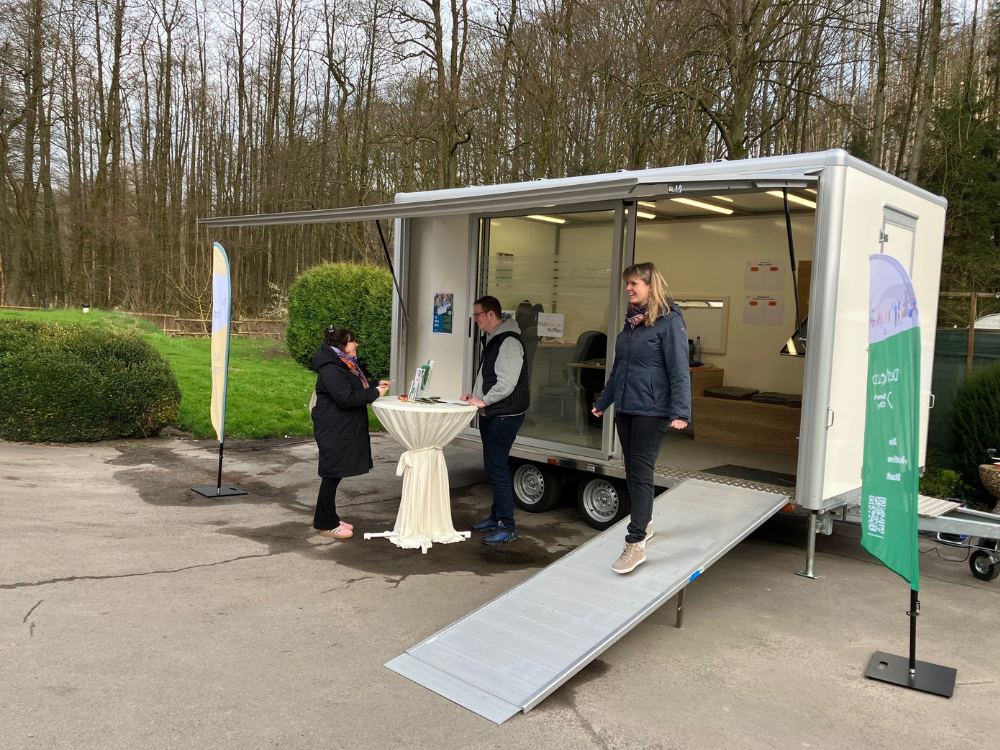 Das Foto zeigt das "Stadtkontakt mobil", bei einem Einsatz im Jahr 2024. Man sieht den begehbaren, städtischen Anhänger, der die Menschen in den Ortsteilen besucht und mit Informationen versorgt.