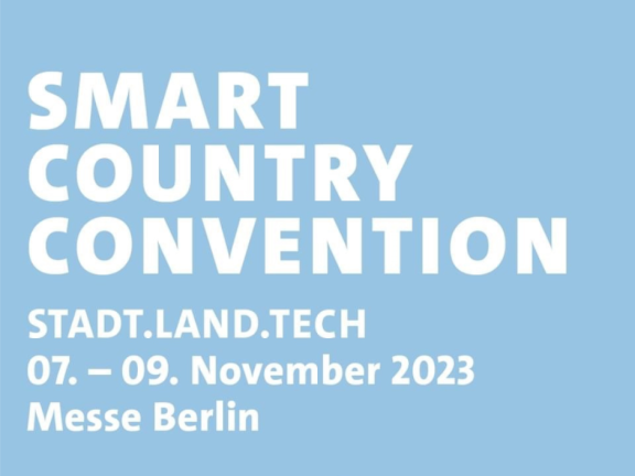Symbolbild: Grafik auf hellblauem Hintergrund mit weißer Schrift: Smart Country Convention • Stadt. Land. Tech 07. - 09. November 2023 Messe Berlin 