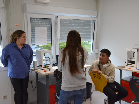 Das Foto zeigt zwei Schüler*innen in dem Container, zusammen mit der Dozentin, die zum Thema 